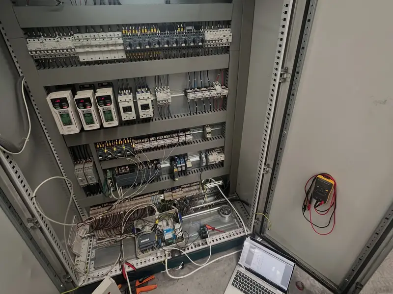 Otvoren elektro ormar s automatikom, pored njega laptop i mjerni instrument